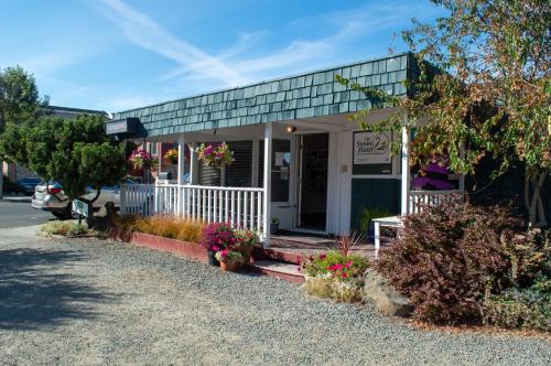 ein kleines Gebäude mit Blumen davor in der Unterkunft The Swan Hotel in Port Townsend