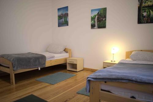 プフォルツハイムにあるGoldstadt Ferienwohnungのベッド2台とランプが備わる部屋