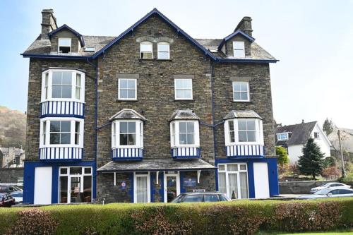 Casa grande de ladrillo marrón con ventanas blancas en Brathay Lodge, en Ambleside