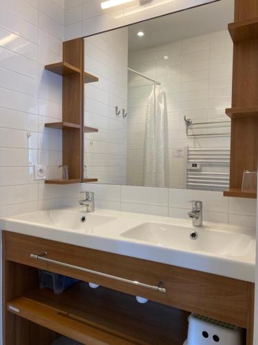 een badkamer met 2 wastafels en een spiegel bij Résidence Belle Plage in La Tranche-sur-Mer