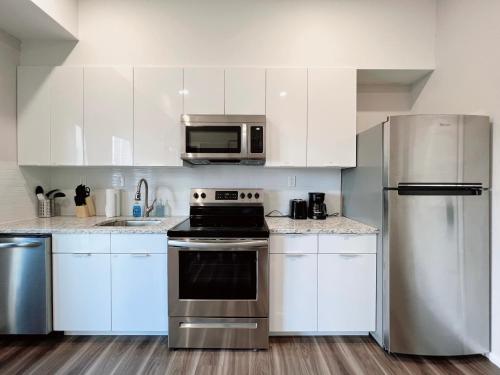 a kitchen with white cabinets and stainless steel appliances at Stay at Luna on Ridge Ave in Philadelphia