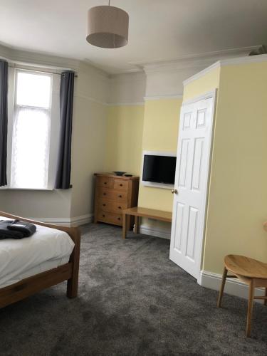 a bedroom with a bed and a tv and a door at The Beach Side in Redcar