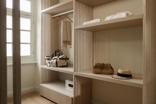 a walk in closet with white shelves and a window at SYROS SOUL LUXURY SUITES in Ermoupoli