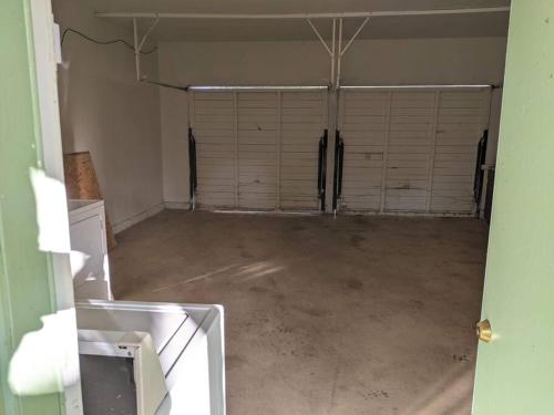 an empty garage with two garage doors in a room at A lake, a mountain and the house with the red door in Clearlake