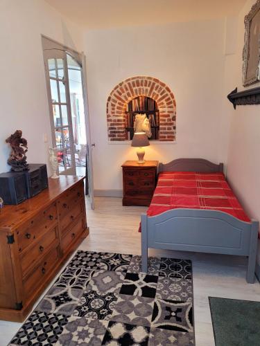 une chambre avec un lit, une commode et un miroir dans l'établissement LE REFUGE, à Saint-Valery-sur-Somme