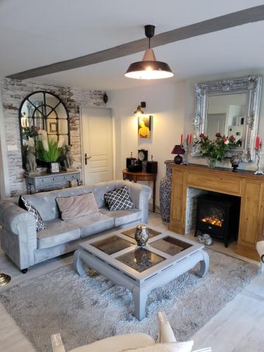 un salon avec un canapé et une cheminée dans l'établissement LE REFUGE, à Saint-Valery-sur-Somme