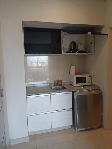a small kitchen with a microwave and a refrigerator at TORRE GUAYASAMIN in Corrientes