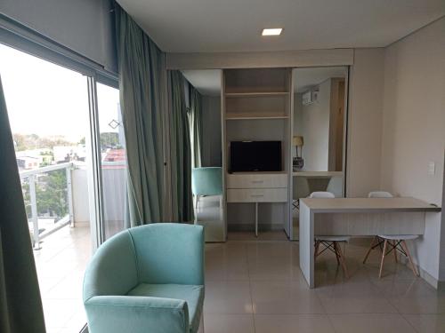 a living room with a blue chair and a television at TORRE GUAYASAMIN in Corrientes
