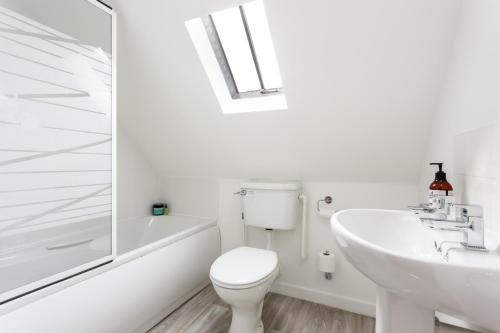 a white bathroom with a toilet and a sink at The Old Butcher's Cottage in Corfe Castle