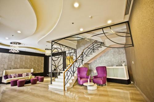 a living room with purple chairs and a staircase at The Exchange Regency Residence Hotel Managed by HII in Manila