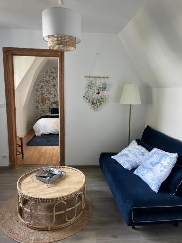 ein Wohnzimmer mit einem blauen Sofa und einem Spiegel in der Unterkunft Le Pons Episcopi in Pont-lʼÉvêque