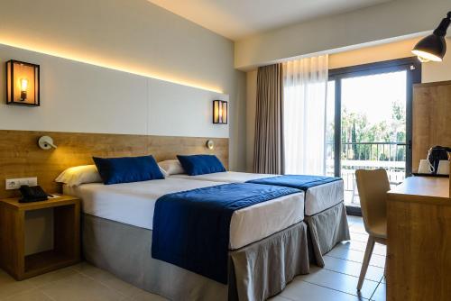 a hotel room with a bed and a balcony at Estival ElDorado Resort in Cambrils