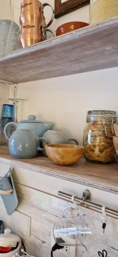 a shelf with bowls and other items on it at Bologna Minimal Chic House Relax Parking Nature Near Center in Bologna