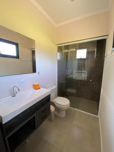 a bathroom with a sink and a toilet and a shower at Casa na Serra Gaúcha in Igrejinha