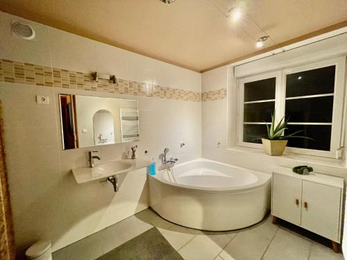 une salle de bain blanche avec une baignoire et un lavabo dans l'établissement Grande maison Saint Malo avec cheminée et jardin, à Saint-Malo