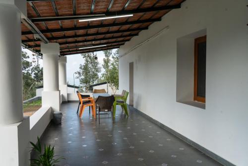 a patio with a table and chairs on a house at The Inglewood Bungalow in Yercaud