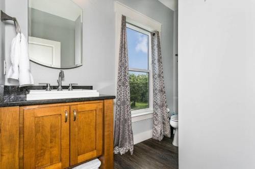 La salle de bains est pourvue d'un lavabo et d'une fenêtre. dans l'établissement Welcome to Sea Cow, à Oriole Beach