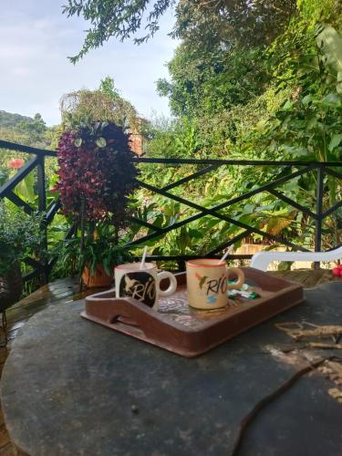 a tray of mugs sitting on a table at Sendero del Rio Finca Hotel in San Rafael