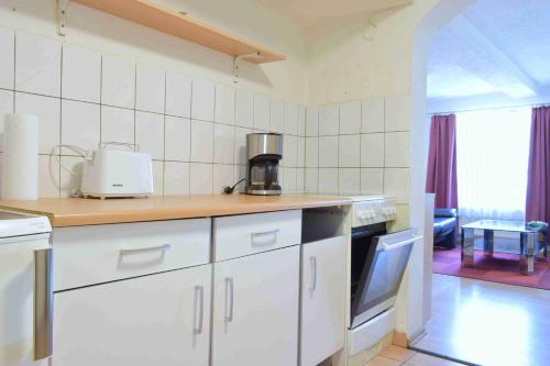 カルフにあるFerienwohnung Hermann Hesse Stadtの白いキャビネットとカウンタートップを備えたキッチン