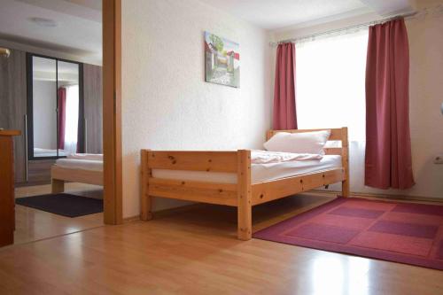 カルフにあるFerienwohnung Hermann Hesse Stadtのベッドルーム1室(木製ベッド1台、窓付)