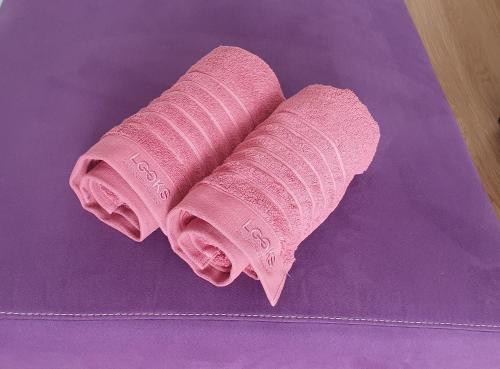 un par de toallas rosas sentadas sobre una toalla púrpura en Bed&Coffee&Go, en Trier