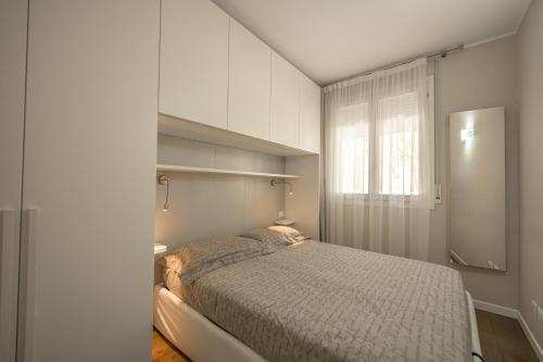 una piccola camera con letto e finestra di Appartamento incantevole con piscina a Vallecrosia