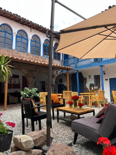 a patio with a table and an umbrella at CASA CRISTOBAL Siete Cuartones in Cusco