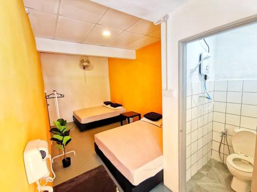 a bathroom with two beds and a shower and a toilet at The Cocoon Capsule Hotel in Cameron Highlands