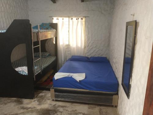 a small room with a bed and a mirror at Cabaña El Tucan in Minca