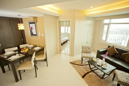 a living room with a couch and a dining room at The Exchange Regency Residence Hotel Managed by HII in Manila