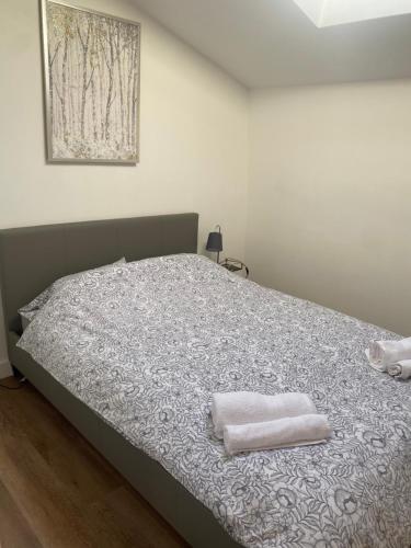 a bedroom with a bed with two towels on it at 2 Bedroom Central Apartment in Leek