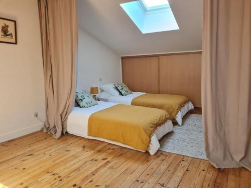 two beds in a room with a skylight at Maison de Campagne cosy in Pons