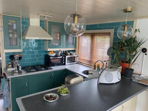 a kitchen with green cabinets and a black counter top at Woonark Westeinder with kayaks close to Schiphol Airport in Aalsmeer
