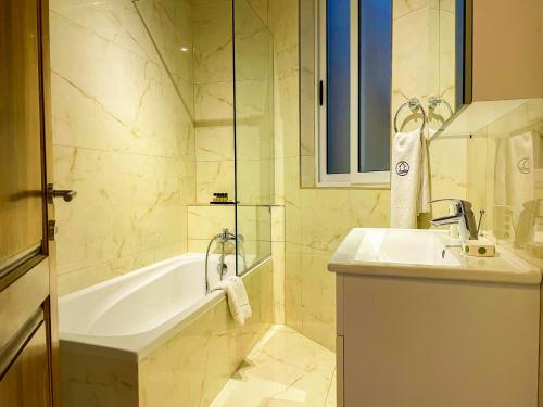La salle de bains est pourvue d'une baignoire et d'un lavabo. dans l'établissement Inni Holiday Home with Infinity Pool, à L-Għarb