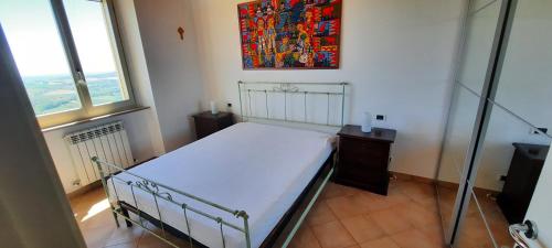 una camera da letto con un letto e un dipinto sul muro di appartamento in contesto esclusivo in pieno centro a Camerano