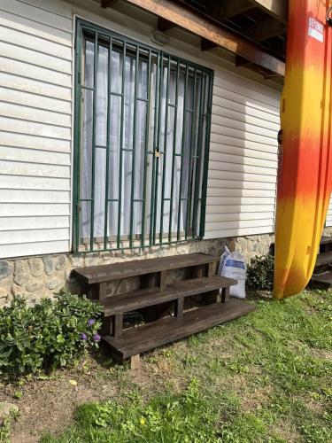 a wooden bench sitting in front of a house at Primavera y dias de sol en Cabaña Roscoe's Paradise Playa Los Molles- 2 -3 personas in Los Molles