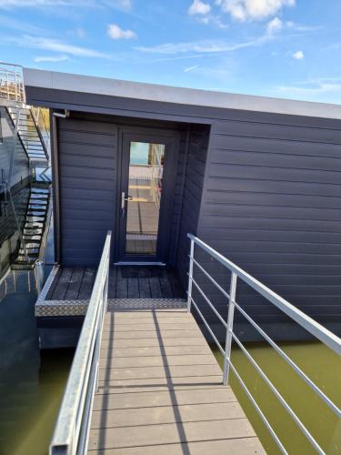 a walkway leading to a building with a door at Hausboot auf dem Wangermeer in Wangerland