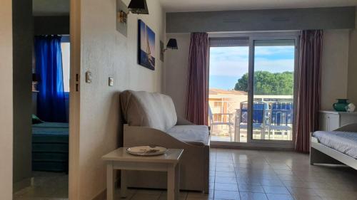 un soggiorno con sedia e vista su un balcone di Appartamento vista splendida Residence du Golf a Golfe-Juan