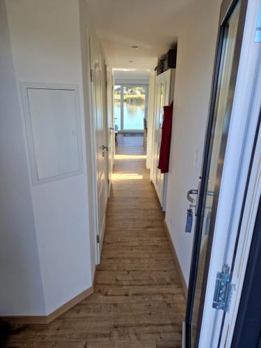 un pasillo con una puerta y un pasillo largo en Hausboot auf dem Wangermeer, en Wangerland