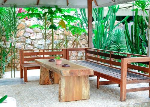 a wooden bench and a table on a patio at Danka Vacation Home in Seribu