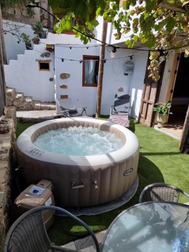 vasca idromassaggio in un cortile con 2 sedie di El Nido Fuente Hervera. Precioso Loft con Bañera de Hidromasaje a Vega de San Mateo