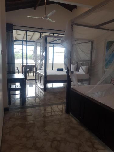 a room with two bunk beds and a table at Sea Port Hiriketiya in Hiriketiya