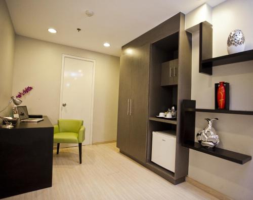 an office with a green chair and a desk at The Exchange Regency Residence Hotel Managed by HII in Manila