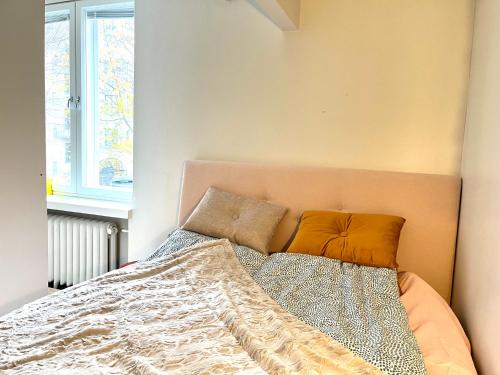 ein Bett mit zwei Kissen darauf in einem Schlafzimmer in der Unterkunft Villa Centralen in Helsinki