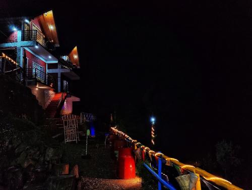 a night time picture of a building with lights at Gadegal Homestay Narkanda - Rooms & Pahadi Café in Shimla