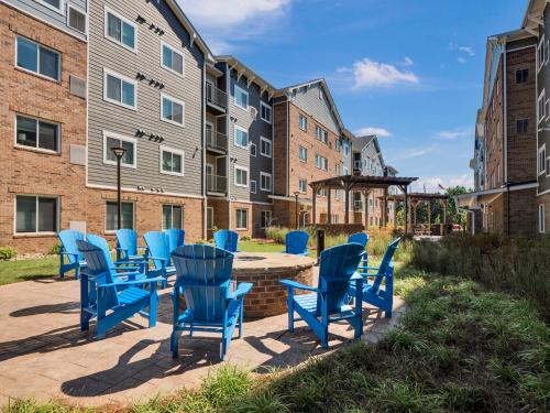 a group of blue chairs sitting in front of a building at WaterWalk Extended Stay by Wyndham Charlotte - Arrowood in Charlotte