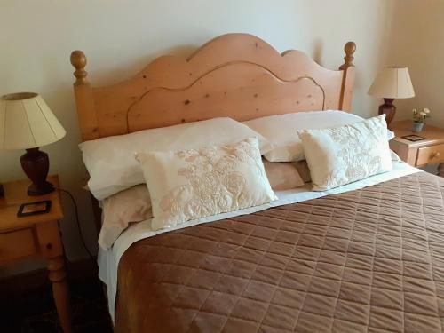 a bedroom with a bed with white pillows at Cornode Cottage in Garrykennedy