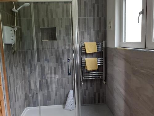 La salle de bains est pourvue d'une douche, d'une baignoire et d'un lavabo. dans l'établissement Cornode Cottage, à Garrykennedy