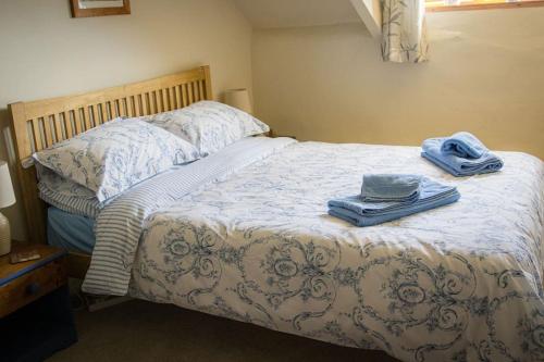 1 dormitorio con 1 cama con toallas en Batney Farm Cottage, Meshaw, South Molton, en South Molton