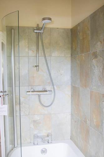 a shower in a bathroom with a sink and a tub at Batney Farm Cottage, Meshaw, South Molton in South Molton